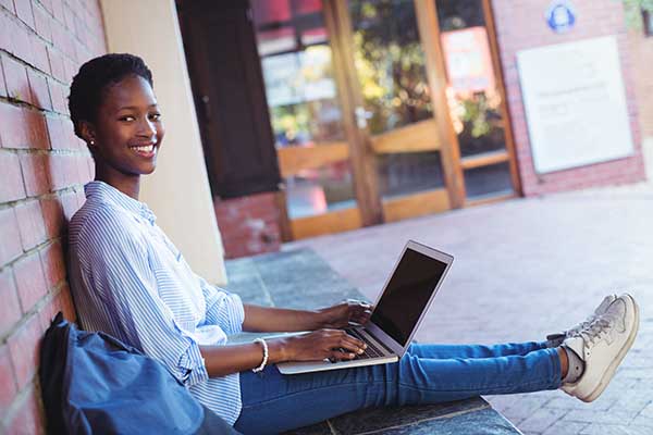 girl doing schoolwork with laptop